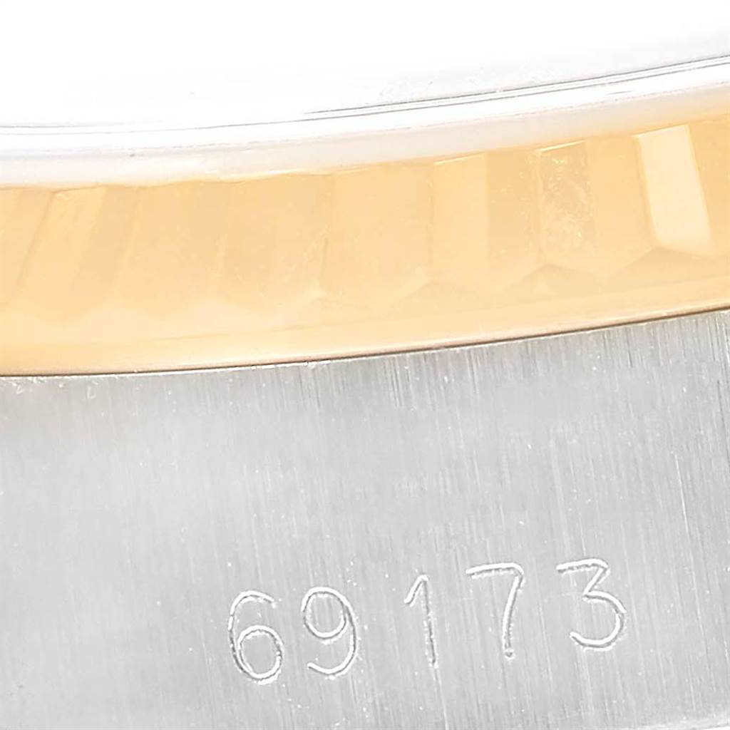 This close-up angle of the Rolex Datejust 69173 Women's Stainless Steel Grey Dial 69173 Women's Stainless Steel Grey Dial watch showcases its fluted bezel and part of its case with the model number 69173 engraved.