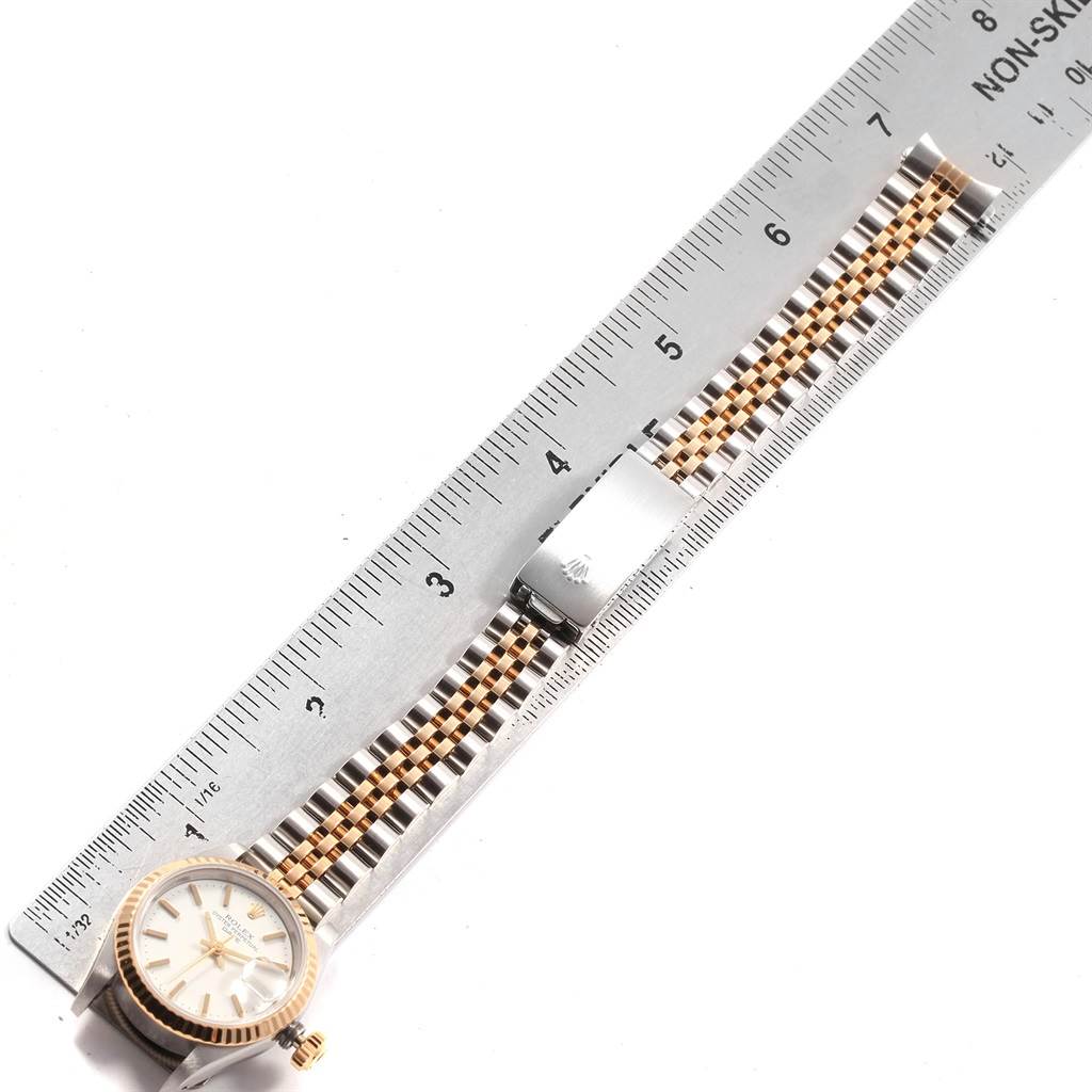 The Rolex Datejust 69173 Women's Stainless Steel White Dial 69173 Women's Stainless Steel White Dial watch is shown from a top-down angle, highlighting the face, bezel, and bracelet next to a ruler.