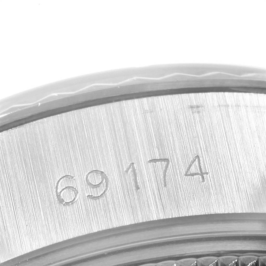 The image shows a close-up of the Rolex Datejust 69174 Women's Stainless Steel Silver Dial 69174 Women's Stainless Steel Silver Dial model's watch case with the serial number 69174 engraved.