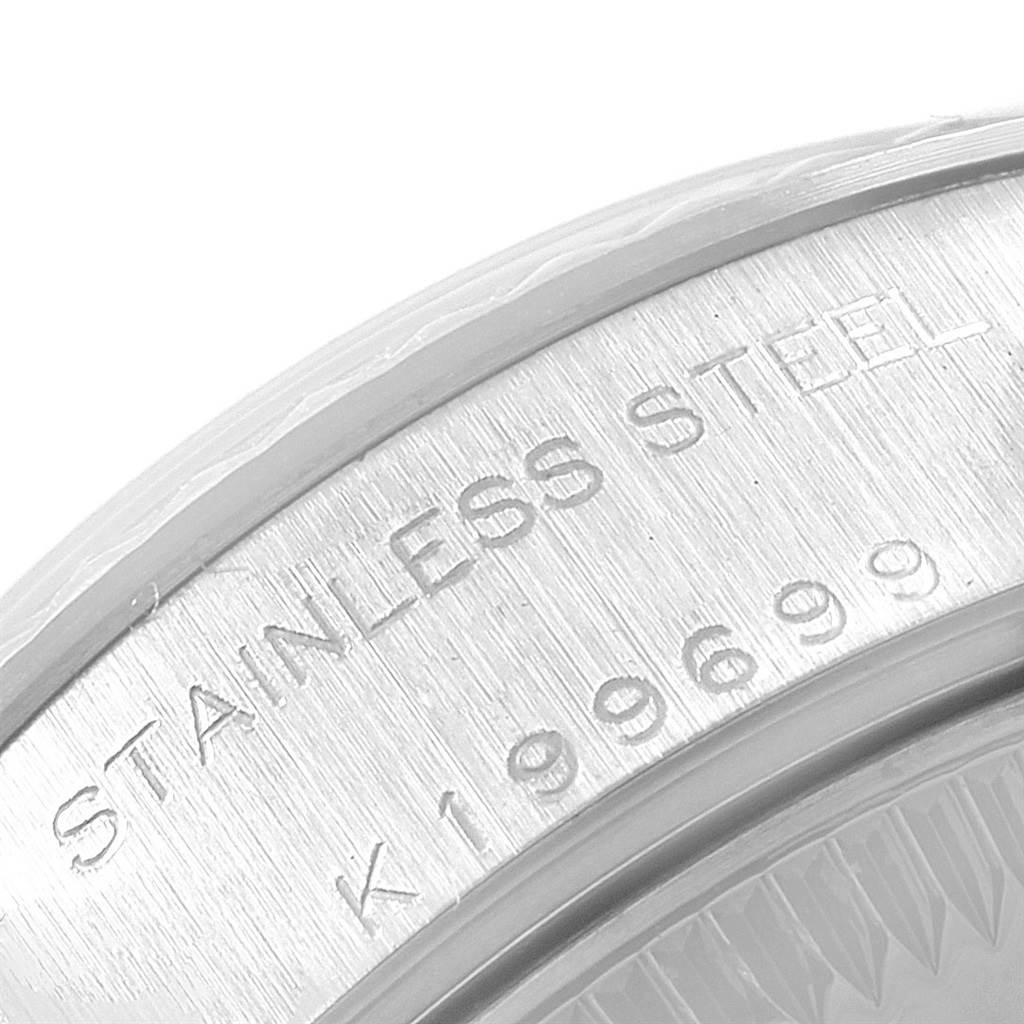 This image shows a close-up of the case back edge of the Rolex Datejust 79174 Women
s Stainless Steel Pink Dial 79174 Women
s Stainless Steel Pink Dial, highlighting the engraved text "STAINLESS STEEL" and serial number.