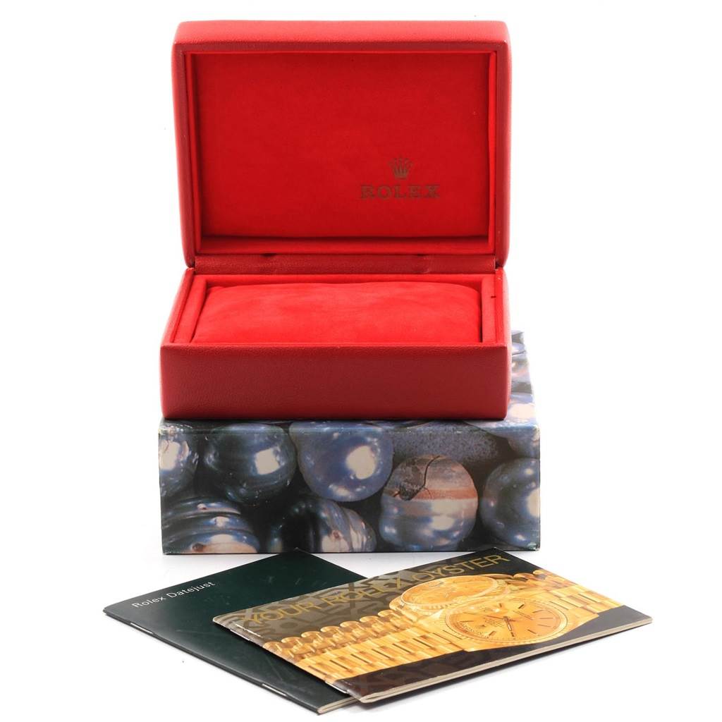 The image shows an open red Rolex box for the Datejust model with accompanying booklets placed in front.