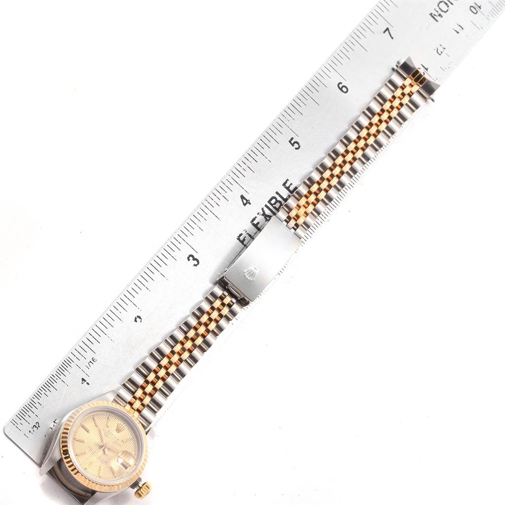 This image shows a top-down view of a Rolex Datejust 69173 Women's Stainless Steel Champagne Dial 69173 Women's Stainless Steel Champagne Dial watch with a ruler alongside it, displaying its bracelet and clasp.