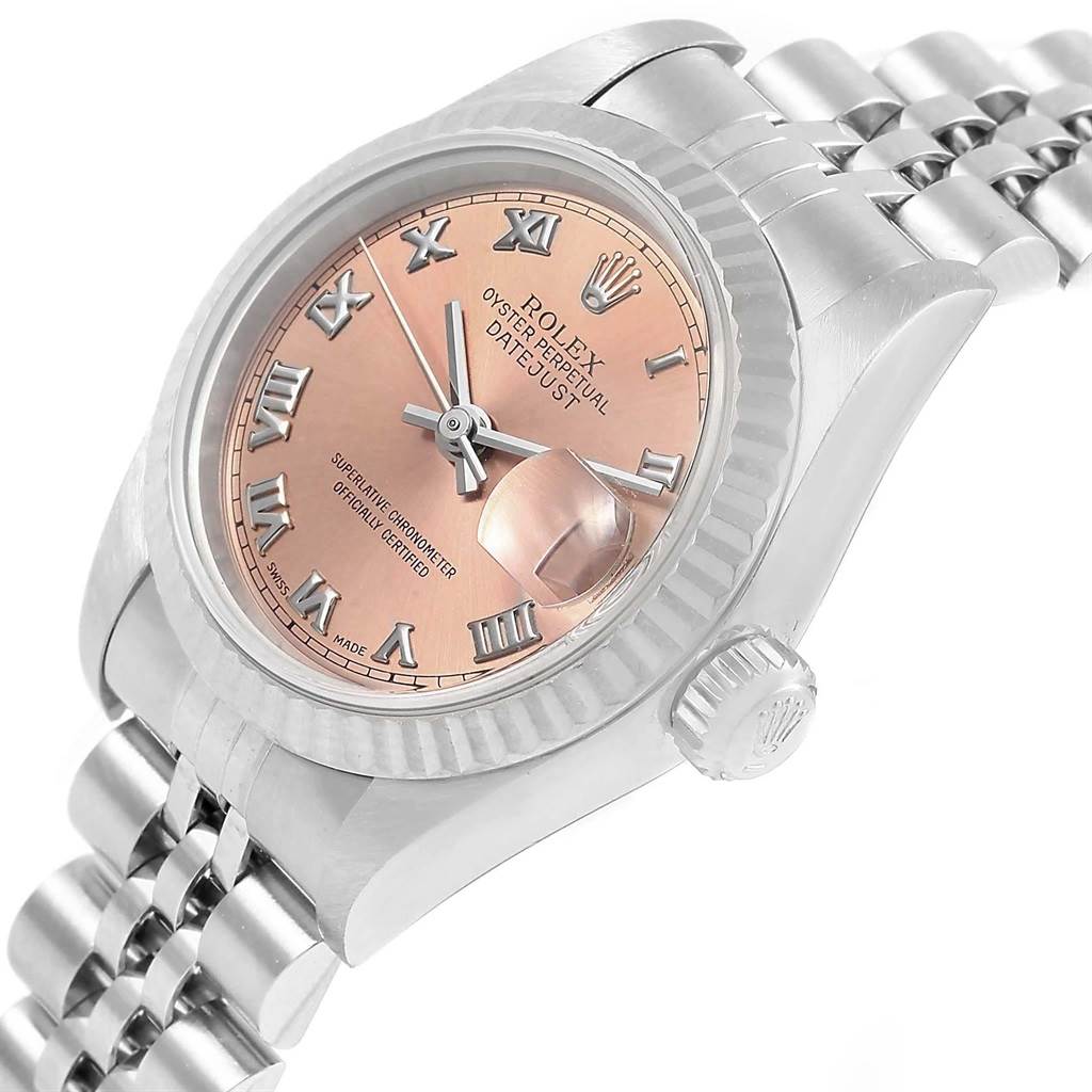 The Rolex Datejust 79174 Women's Stainless Steel Pink Dial 79174 Women's Stainless Steel Pink Dial watch is shown at a slight angle, highlighting its pink dial, Roman numerals, fluted bezel, and bracelet.