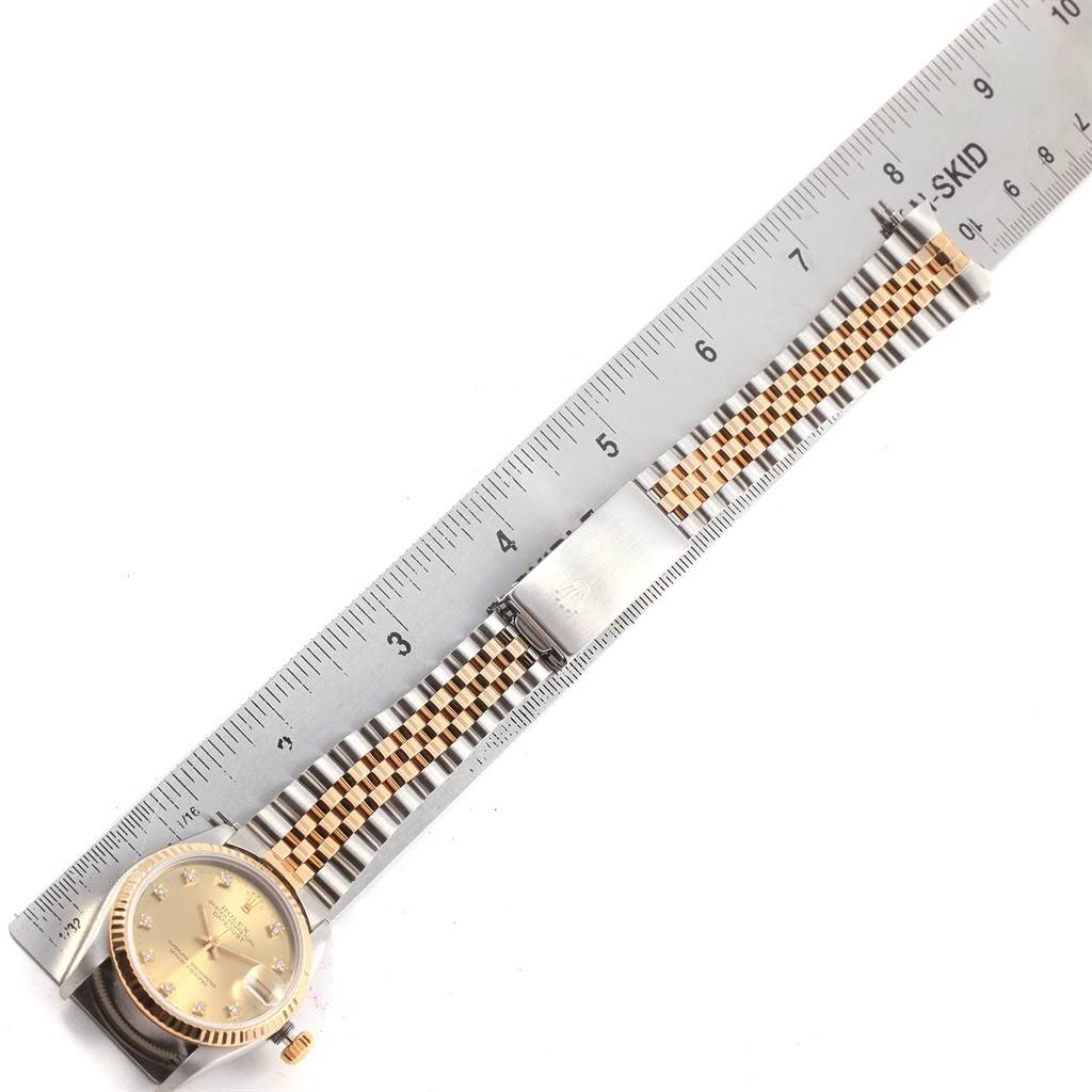 This image shows a Rolex Datejust 68273 Women's Steel and Gold (two tone) Champagne Dial 68273 Women's Steel and Gold (two tone) Champagne Dial watch laid flat with the band extended alongside a ruler for measurement.