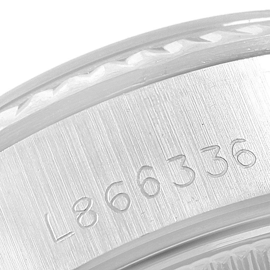 The image shows a close-up angle of the bezel and case of a Rolex Datejust 69174 Women
s Stainless Steel Pink Dial 69174 Women
s Stainless Steel Pink Dial watch, revealing the serial number engraved on the side.