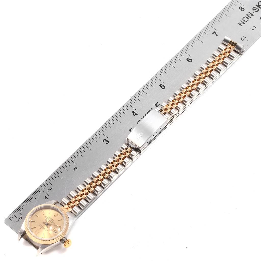 A Rolex Datejust 69173 Women's Stainless Steel Champagne Dial 69173 Women's Stainless Steel Champagne Dial watch shown from a top-down angle next to a ruler, displaying its face, bracelet, and clasp.