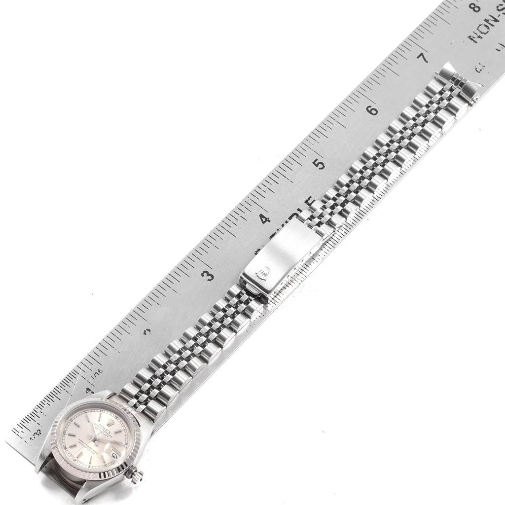 This Rolex Datejust 69174 Women's Stainless Steel Silver Dial 69174 Women's Stainless Steel Silver Dial watch is shown from a top-down angle featuring the face, bracelet, and clasp alongside a ruler.