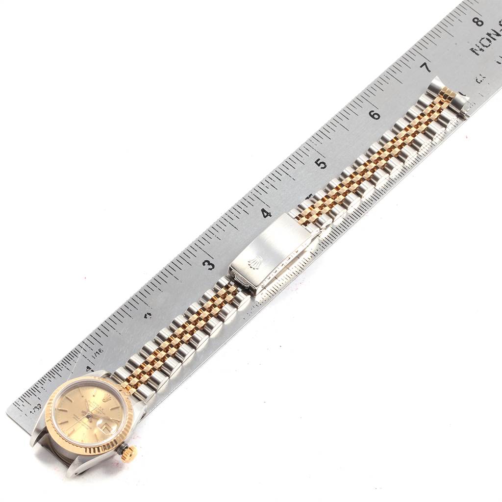 The Rolex Datejust 69173 Women's Stainless Steel Champagne Dial 69173 Women's Stainless Steel Champagne Dial watch is shown flat from above, alongside a ruler, displaying the face, bracelet, and clasp.