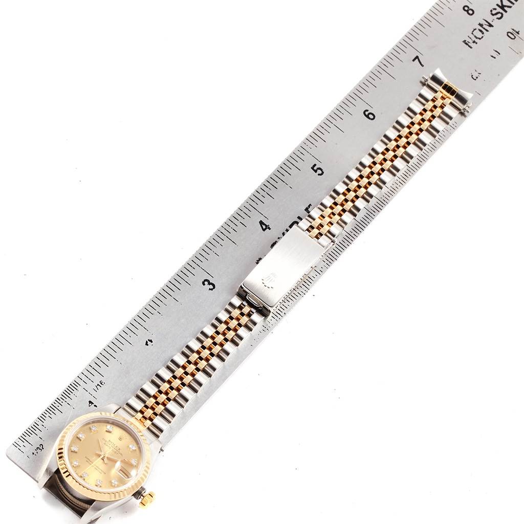 Shown is a Rolex Datejust 69173 Women's Stainless Steel Champagne Dial 69173 Women's Stainless Steel Champagne Dial watch laid flat with its bracelet extended along a ruler for measurement.
