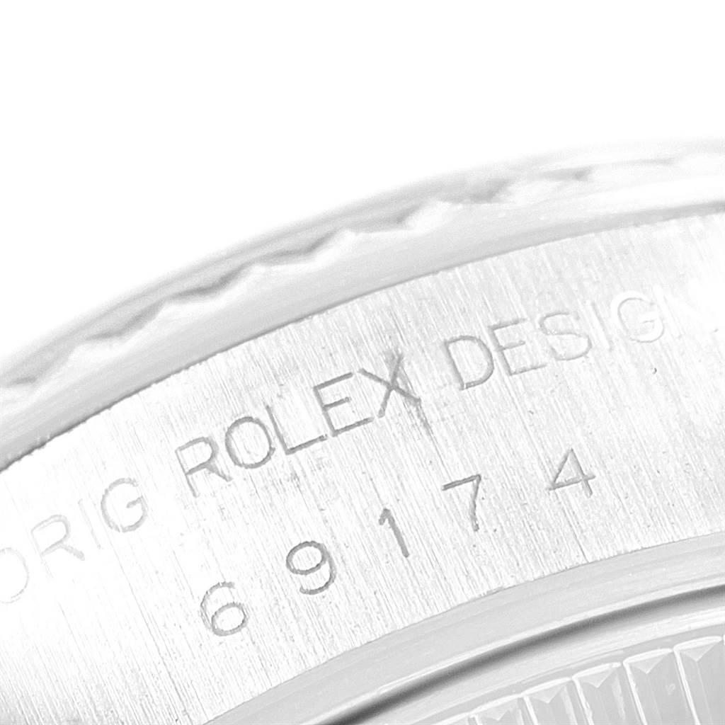 The image shows a close-up of the case back edge of the Rolex Datejust 69174 Women
s Stainless Steel Pink Dial 69174 Women
s Stainless Steel Pink Dial, highlighting part of the serial number and “Rolex Design” engraving.