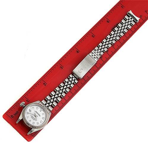The Rolex Datejust 69174 Women's Stainless Steel White Dial 69174 Women's Stainless Steel White Dial watch is shown laid flat next to a red ruler, displaying the face, bracelet, and clasp from a top-down angle.