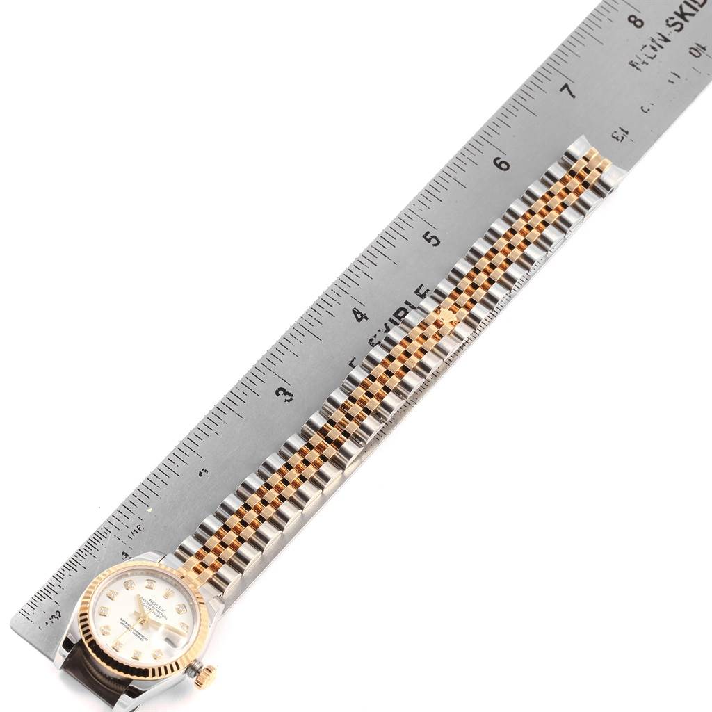 The image shows a top view of a Rolex Datejust 179173 Women's Steel and Gold (two tone) Silver Dial 179173 Women's Steel and Gold (two tone) Silver Dial watch, focusing on its gold and silver jubilee bracelet laid next to a ruler.