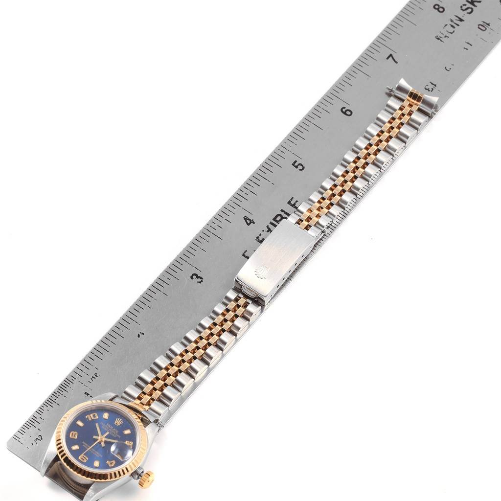 The image shows a Rolex Datejust 69173 Women's Stainless Steel Blue Dial 69173 Women's Stainless Steel Blue Dial watch laid flat, parallel to a ruler, showcasing its bracelet, clasp, and part of the dial.