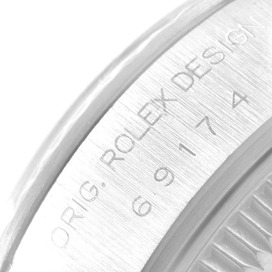 This image shows a close-up of the engraved bezel and serial number of a Rolex Datejust 69174 Women's Stainless Steel Blue Dial 69174 Women's Stainless Steel Blue Dial watch.