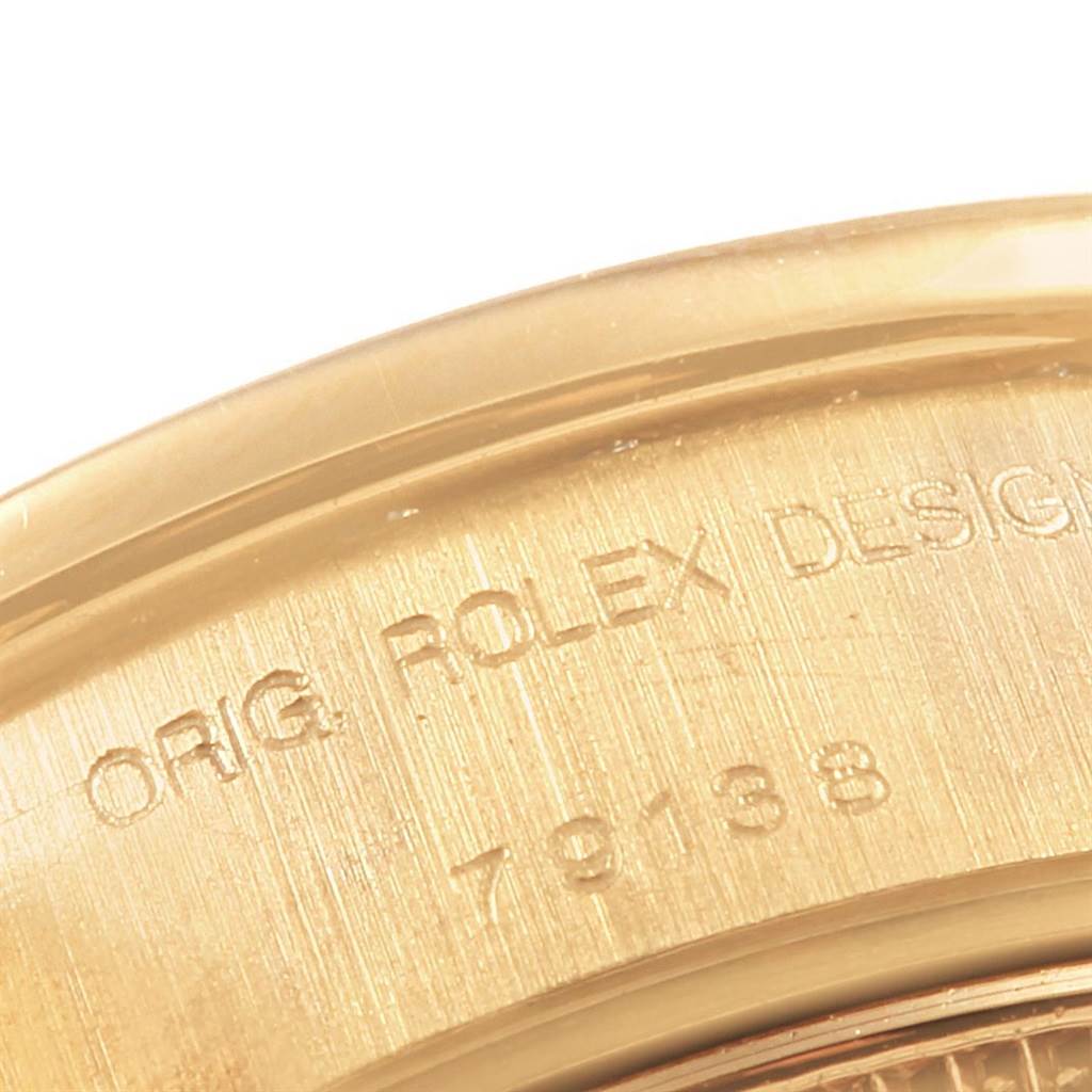 This close-up shows the engraved case back edge of the Rolex Datejust 79138 Women's Yellow Gold Black Dial 79138 Women's Yellow Gold Black Dial watch.