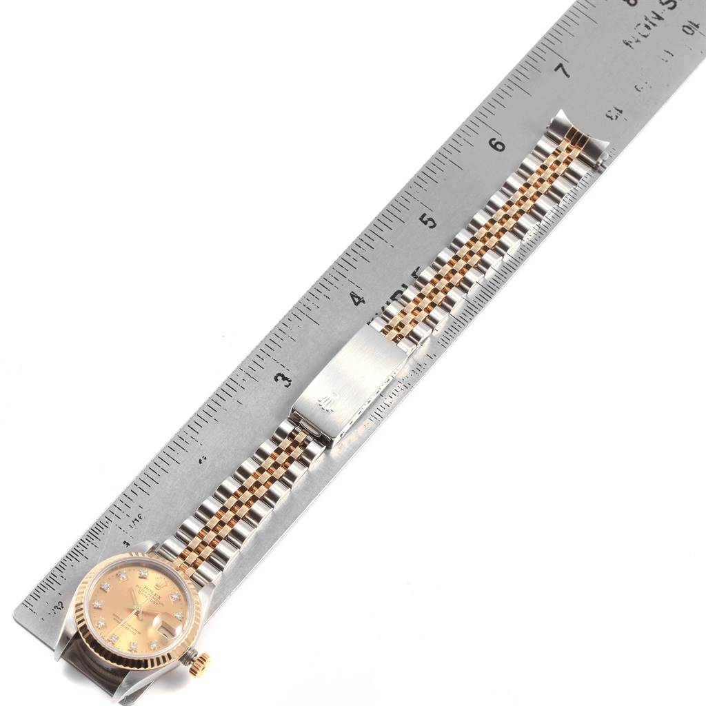 The image shows an overhead view of a Rolex Datejust 69173 Women's Stainless Steel Champagne Dial 69173 Women's Stainless Steel Champagne Dial watch, displaying its dial, bezel, and bracelet next to a ruler for scale.