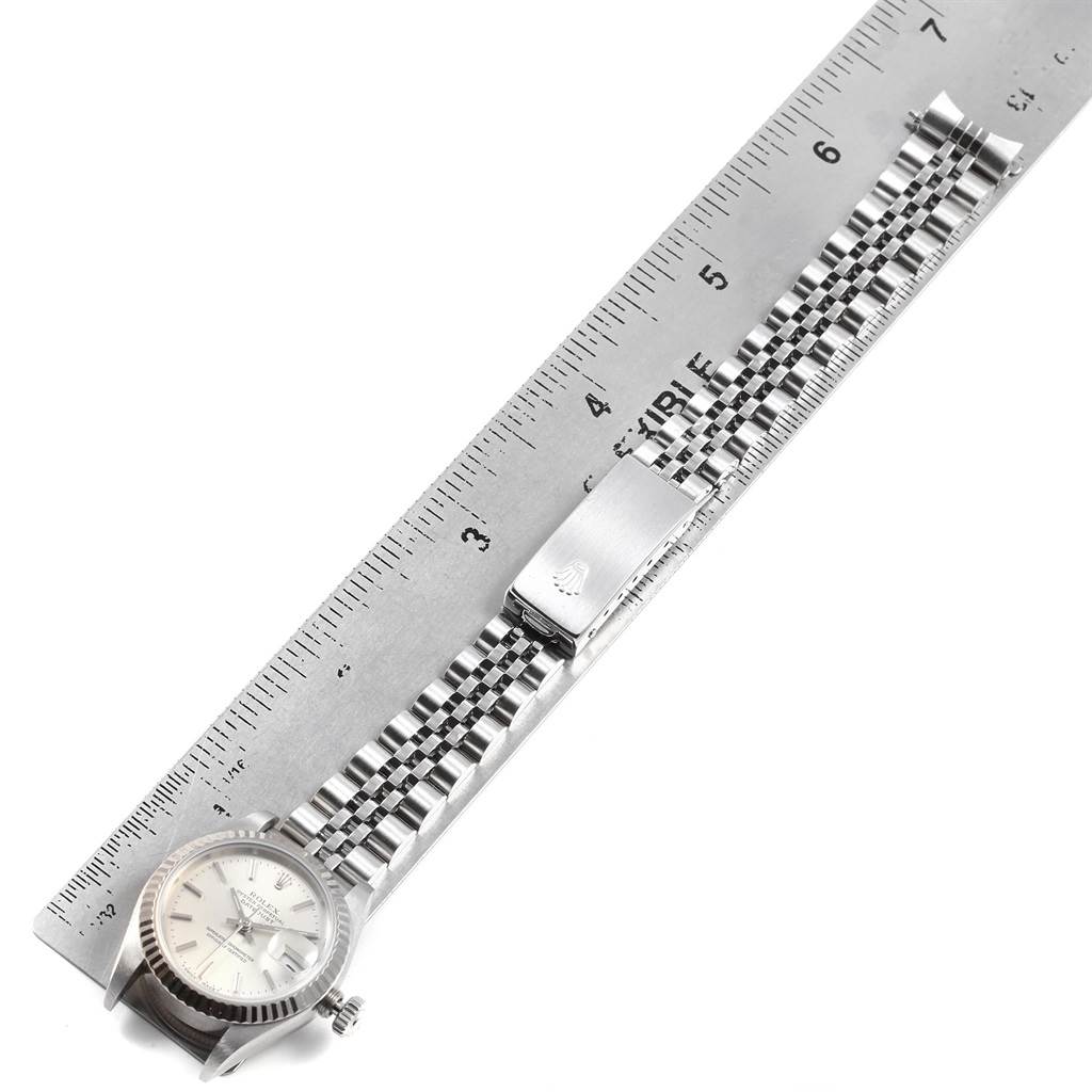 The image shows a Rolex Datejust 69174 Women's Stainless Steel Silver Dial 69174 Women's Stainless Steel Silver Dial watch laid flat beside a ruler, highlighting its bracelet and clasp.