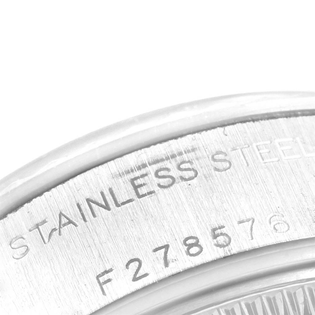 This partial close-up shows the stainless steel casing with engraved serial number of a Rolex Datejust 79174 Women's Stainless Steel Pink Dial 79174 Women's Stainless Steel Pink Dial watch.