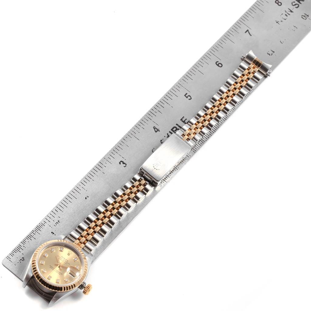 The image shows a Rolex Datejust 69173 Women
s Stainless Steel Champagne Dial 69173 Women
s Stainless Steel Champagne Dial watch laid flat with a metal ruler, highlighting the face, bezel, crown, and bracelet.