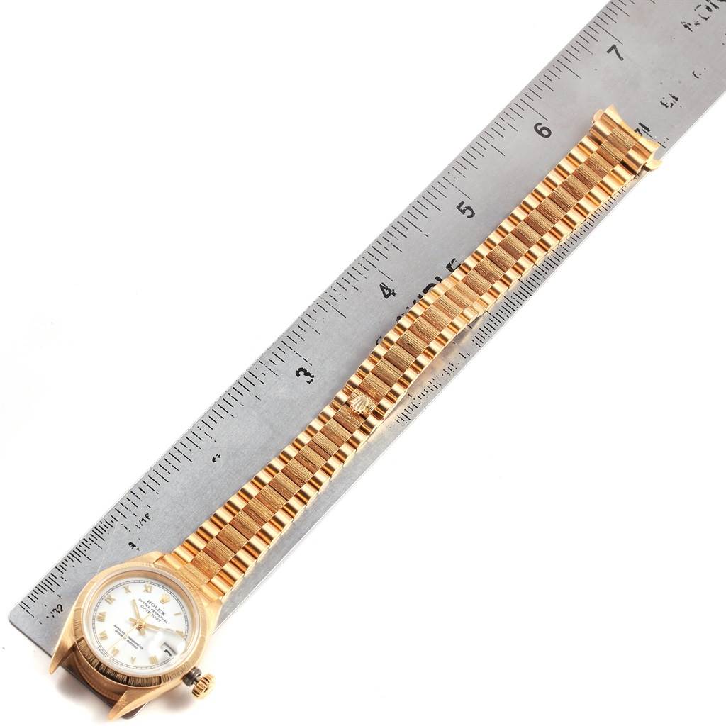 The Rolex Datejust 69278 Women's Yellow Gold White Dial 69278 Women's Yellow Gold White Dial watch is shown from an aerial angle, including the dial, case, and band aligned with a ruler.