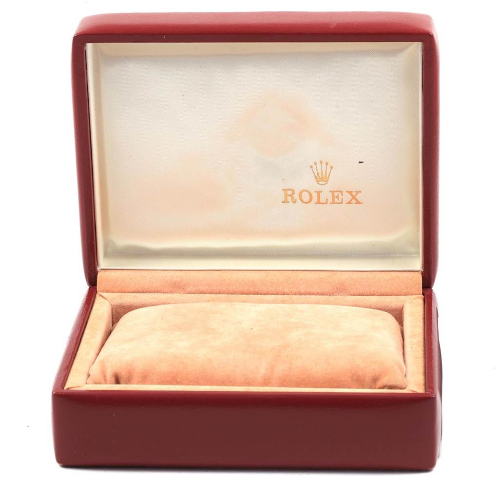 The image shows an open Rolex watch box for the Datejust model, featuring a red exterior and a beige interior with a cushion.