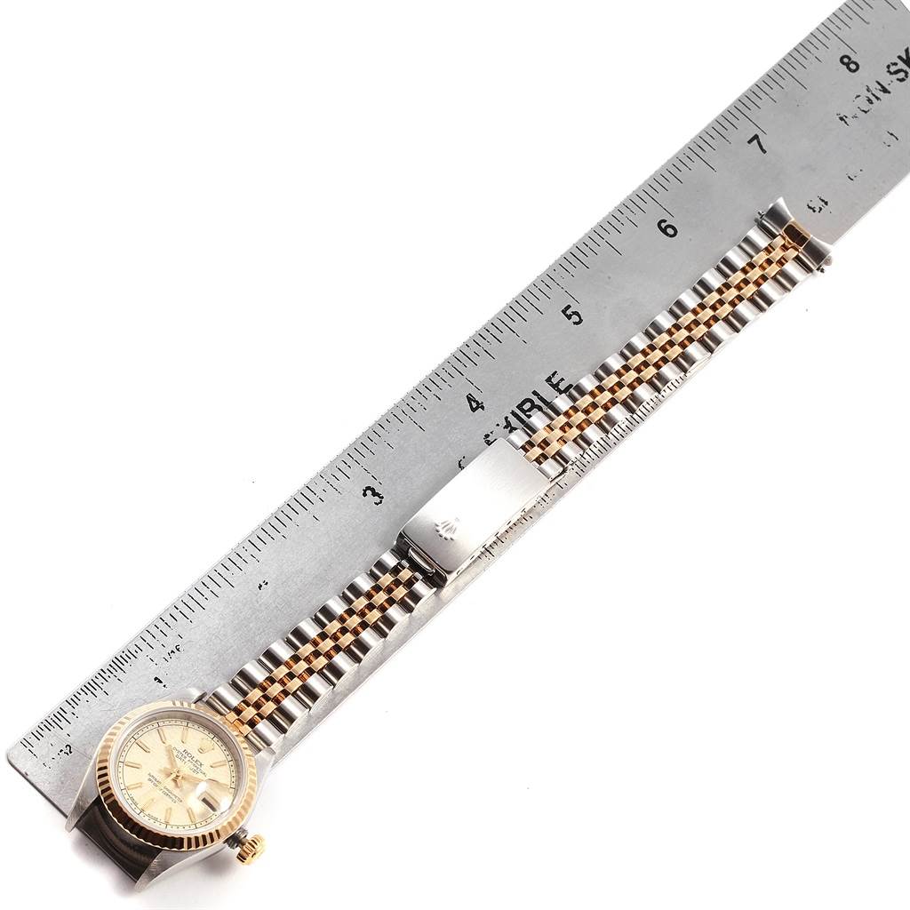 The image shows a Rolex Datejust 69173 Women's Stainless Steel Beige Dial 69173 Women's Stainless Steel Beige Dial model watch laid next to a ruler, emphasizing its bracelet and clasp.