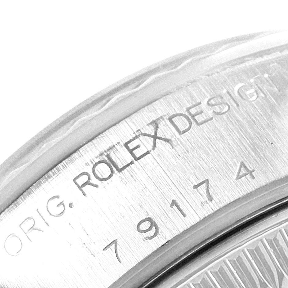 This close-up image shows the engraved serial number and "Rolex Design" on the bezel of a Rolex Datejust 79174 Women
s Stainless Steel Black Dial 79174 Women
s Stainless Steel Black Dial watch.
