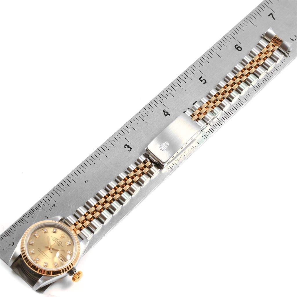 The Rolex Datejust 69173 Women's Stainless Steel Champagne Dial 69173 Women's Stainless Steel Champagne Dial watch is shown flat on a ruler, highlighting the face, jubilee bracelet, and clasp.