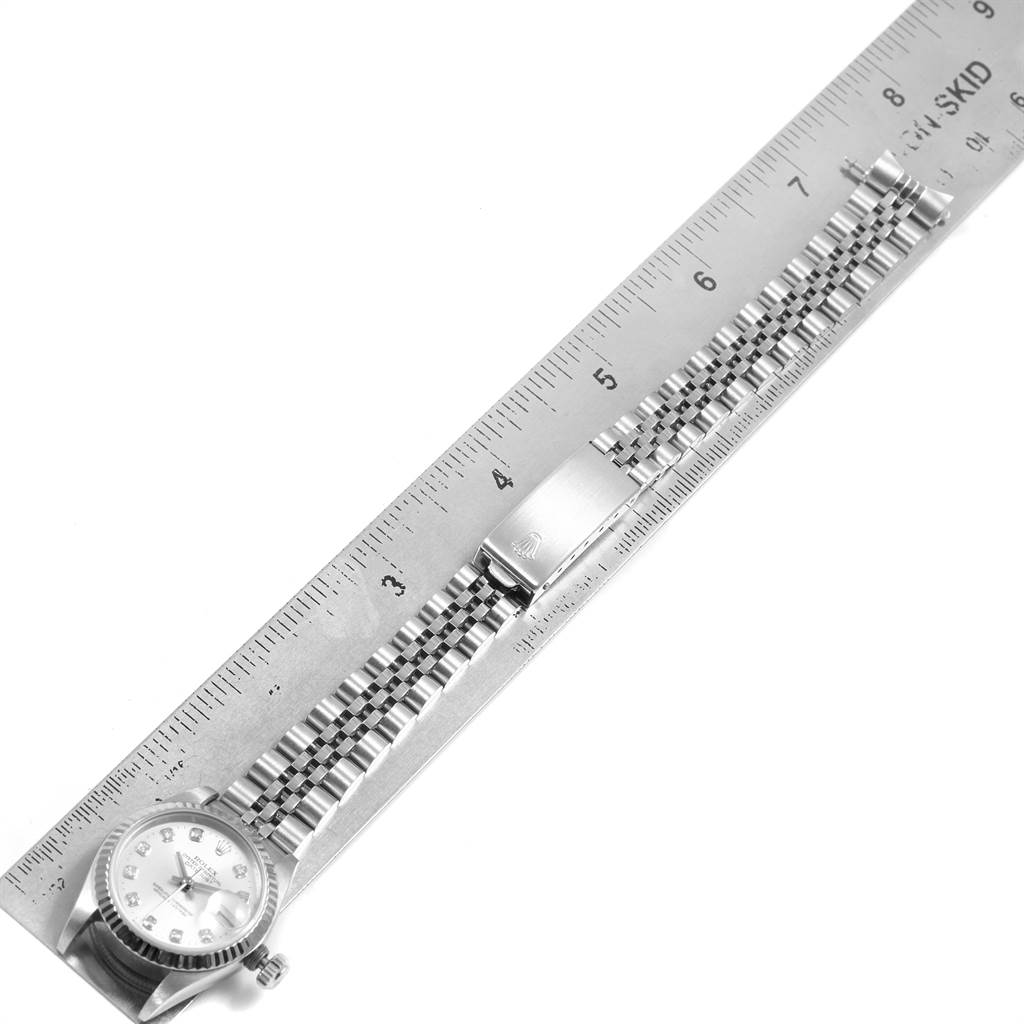 This image shows the Rolex Datejust 69174 Women
s Stainless Steel Silver Dial 69174 Women
s Stainless Steel Silver Dial watch and bracelet laid flat next to a ruler for measurement.