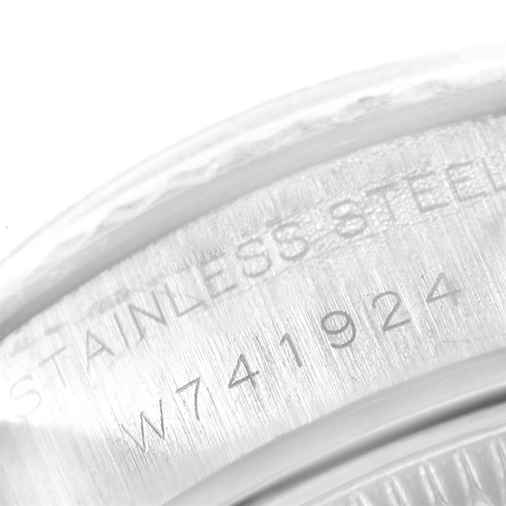 The image shows a close-up of the case back edge of a Rolex Datejust 69174 Women
s Stainless Steel Silver Dial 69174 Women
s Stainless Steel Silver Dial watch, displaying part of the serial number and "STAINLESS STEEL" engraving.