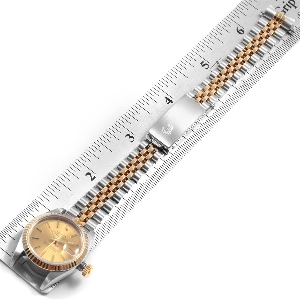 This image shows the Rolex Datejust 69173 Women's Stainless Steel Champagne Dial 69173 Women's Stainless Steel Champagne Dial watch from a top view, highlighting its dial, jubilee bracelet, and clasp with a ruler for scale.