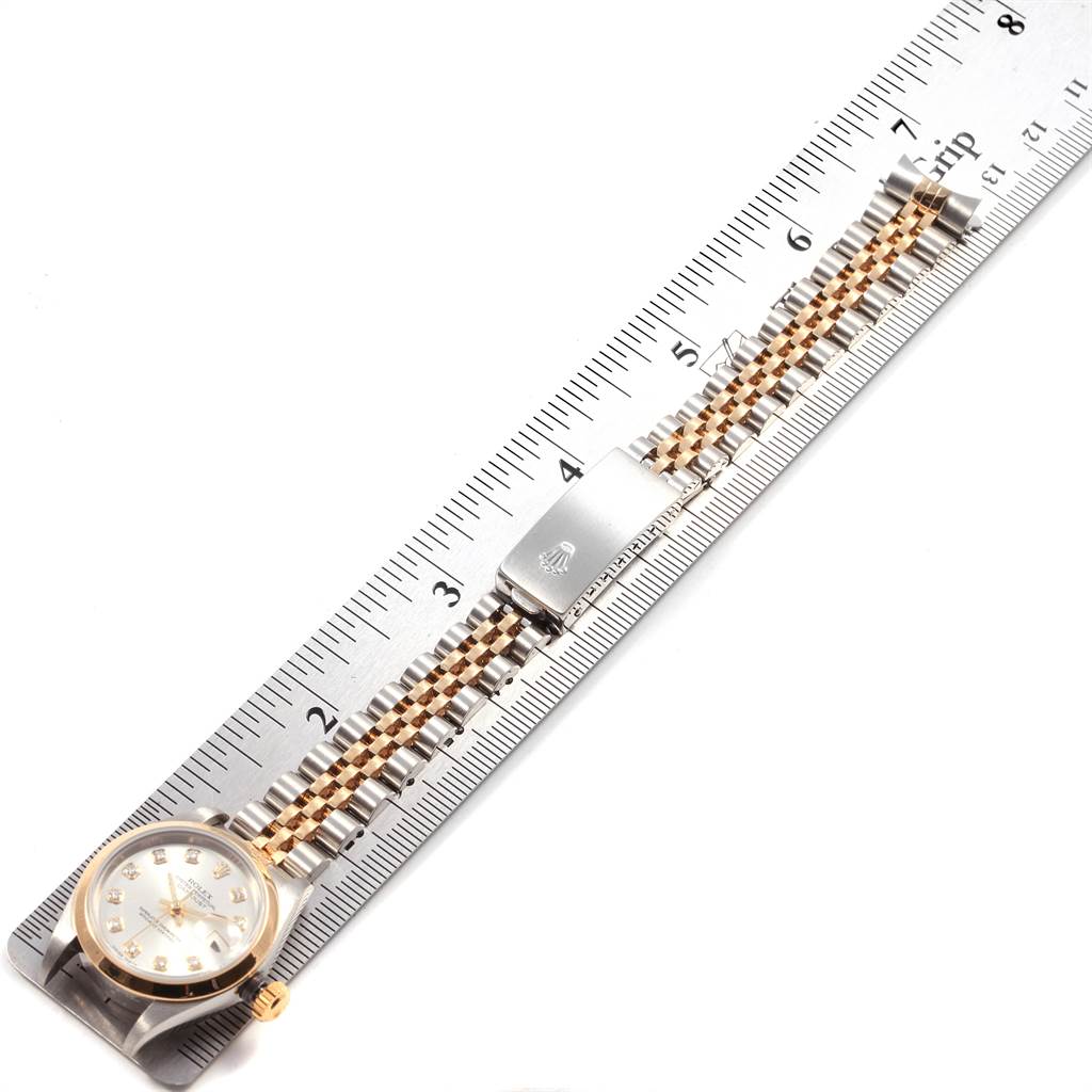 The image shows an overhead view of a Rolex Datejust 79163 Women's Steel and Gold (two tone) Silver Dial 79163 Women's Steel and Gold (two tone) Silver Dial watch next to a ruler, focusing on the face and two-tone bracelet.