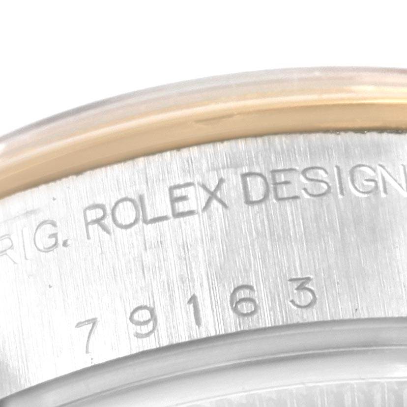 The image shows a close-up of the serial number and "Rolex Design" engraved on the bezel of a Rolex Datejust 79163 Women's Steel and Gold (two tone) Silver Dial 79163 Women's Steel and Gold (two tone) Silver Dial watch.