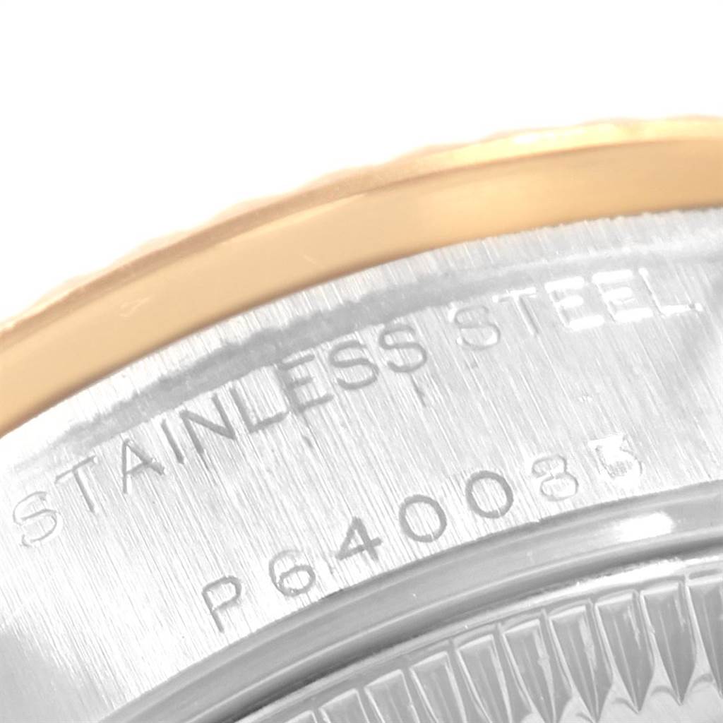 The image shows a close-up of the edge of the case back of a Rolex Datejust 79173 Women's Steel and Gold (two tone) White Dial 79173 Women's Steel and Gold (two tone) White Dial watch, showcasing the engraved serial number and "STAINLESS STEEL" text.