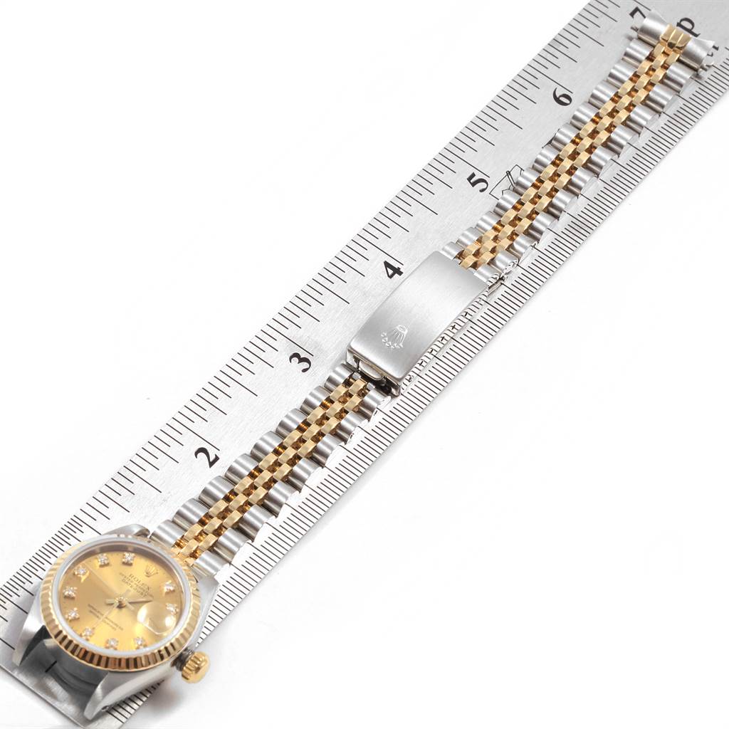 This image shows the Rolex Datejust 69173 Women's Stainless Steel Champagne Dial 69173 Women's Stainless Steel Champagne Dial watch placed flat on a ruler, highlighting the bracelet and clasp.