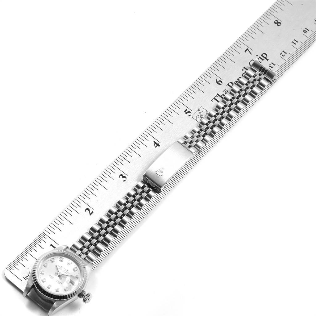 The image shows the Rolex Datejust 69174 Women's Stainless Steel Silver Dial 69174 Women's Stainless Steel Silver Dial watch laid flat, alongside a ruler, focusing on its face and bracelet.