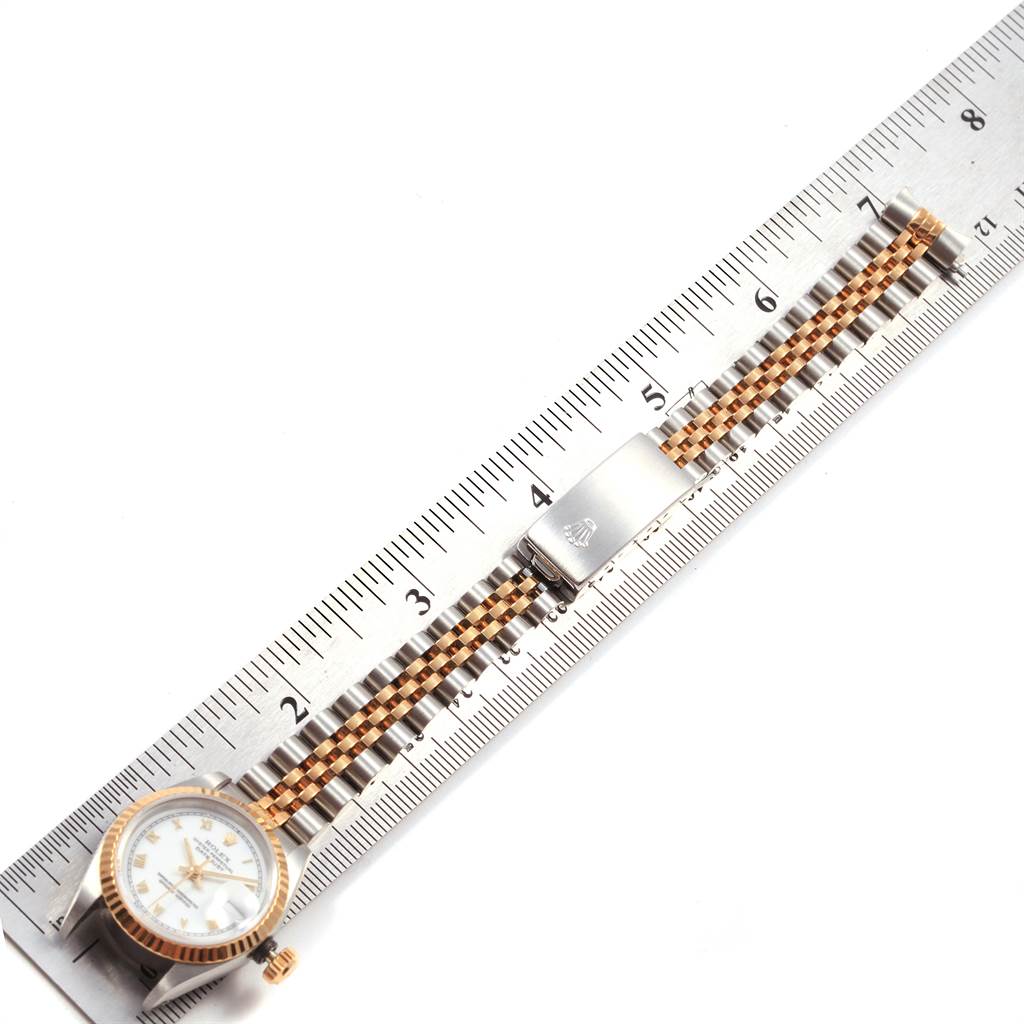 The image shows a top-down view of a Rolex Datejust 69173 Women's Stainless Steel White Dial 69173 Women's Stainless Steel White Dial watch, displaying its face, bracelet, and clasp placed along a ruler.