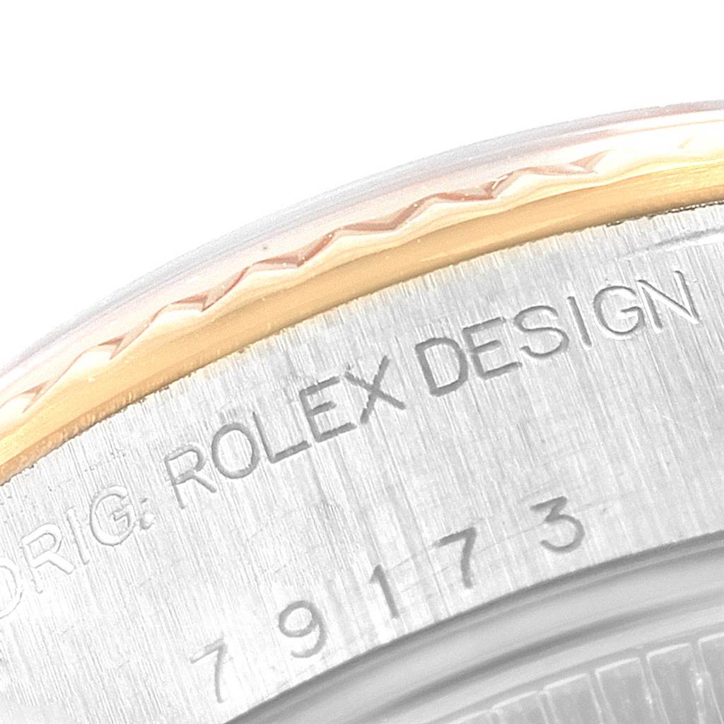 This is a close-up of the caseback rim on a Rolex Datejust 79173 Women's Steel and Gold (two tone) Silver Dial 79173 Women's Steel and Gold (two tone) Silver Dial watch, showing part of the serial number and "ROLEX DESIGN" inscription.