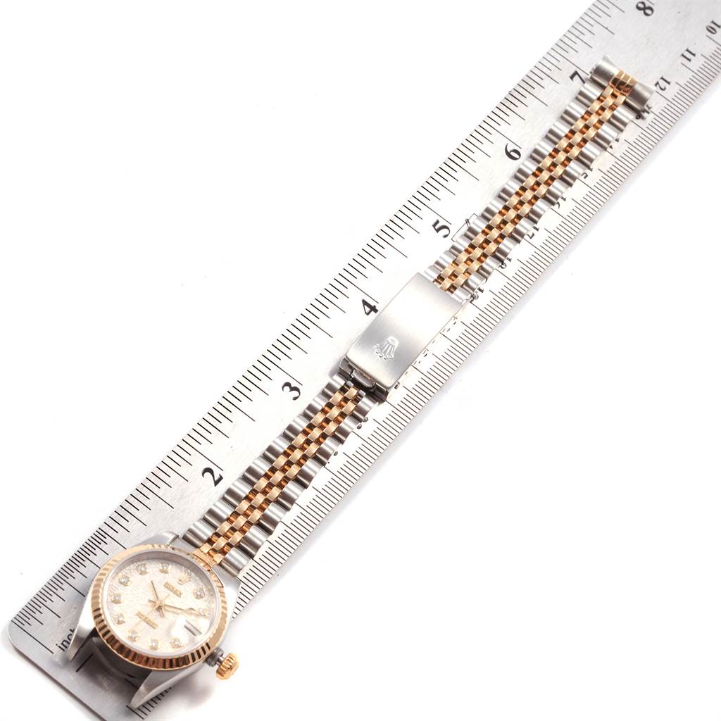 The image shows a Rolex Datejust 79173 Women's Steel and Gold (two tone) Silver Dial 79173 Women's Steel and Gold (two tone) Silver Dial watch laid flat along a ruler, displaying its face, bezel, and bracelet.