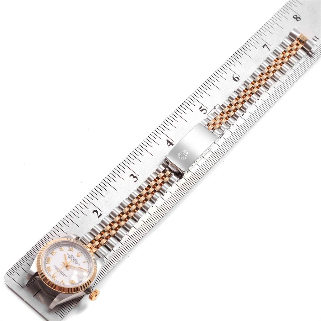 The Rolex Datejust 69173 Women's Stainless Steel White Dial 69173 Women's Stainless Steel White Dial watch is shown from a top-down angle, highlighting its face, bezel, and bracelet placed next to a ruler.