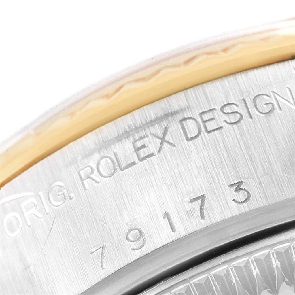 This image shows a close-up of the serial number and "Rolex Design" engraving on the side of a Rolex Datejust 79173 Women
s Steel and Gold (two tone) Black Dial 79173 Women
s Steel and Gold (two tone) Black Dial watch.