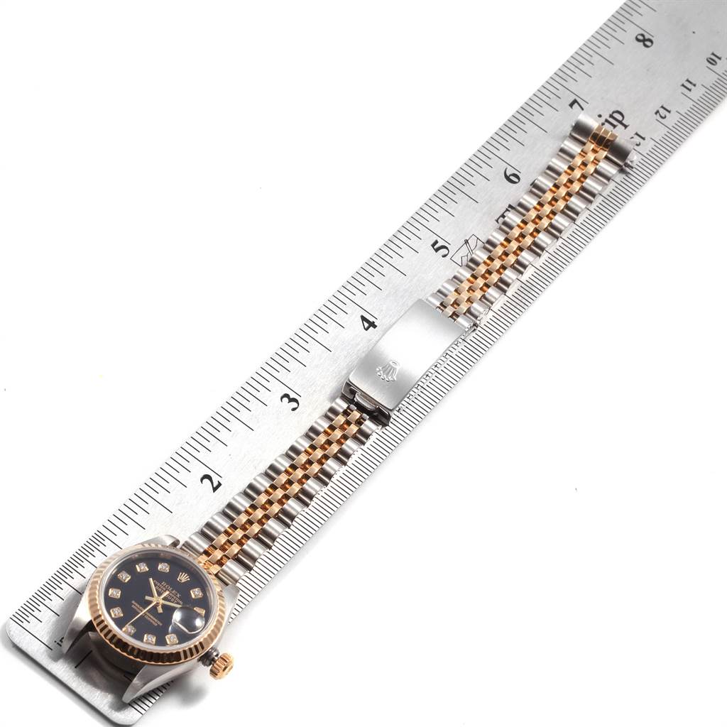 The image shows a Rolex Datejust 79173 Women's Steel and Gold (two tone) Black Dial 79173 Women's Steel and Gold (two tone) Black Dial watch face, crown, and bracelet measured against a ruler.