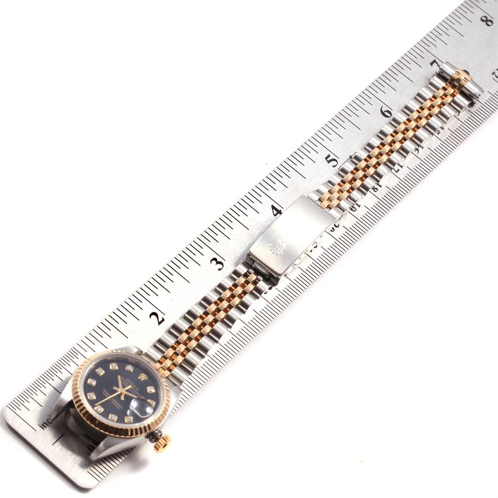 This image shows the Rolex Datejust 69173 Women's Stainless Steel Black Dial 69173 Women's Stainless Steel Black Dial watch laying flat, placed against a ruler for measurement.