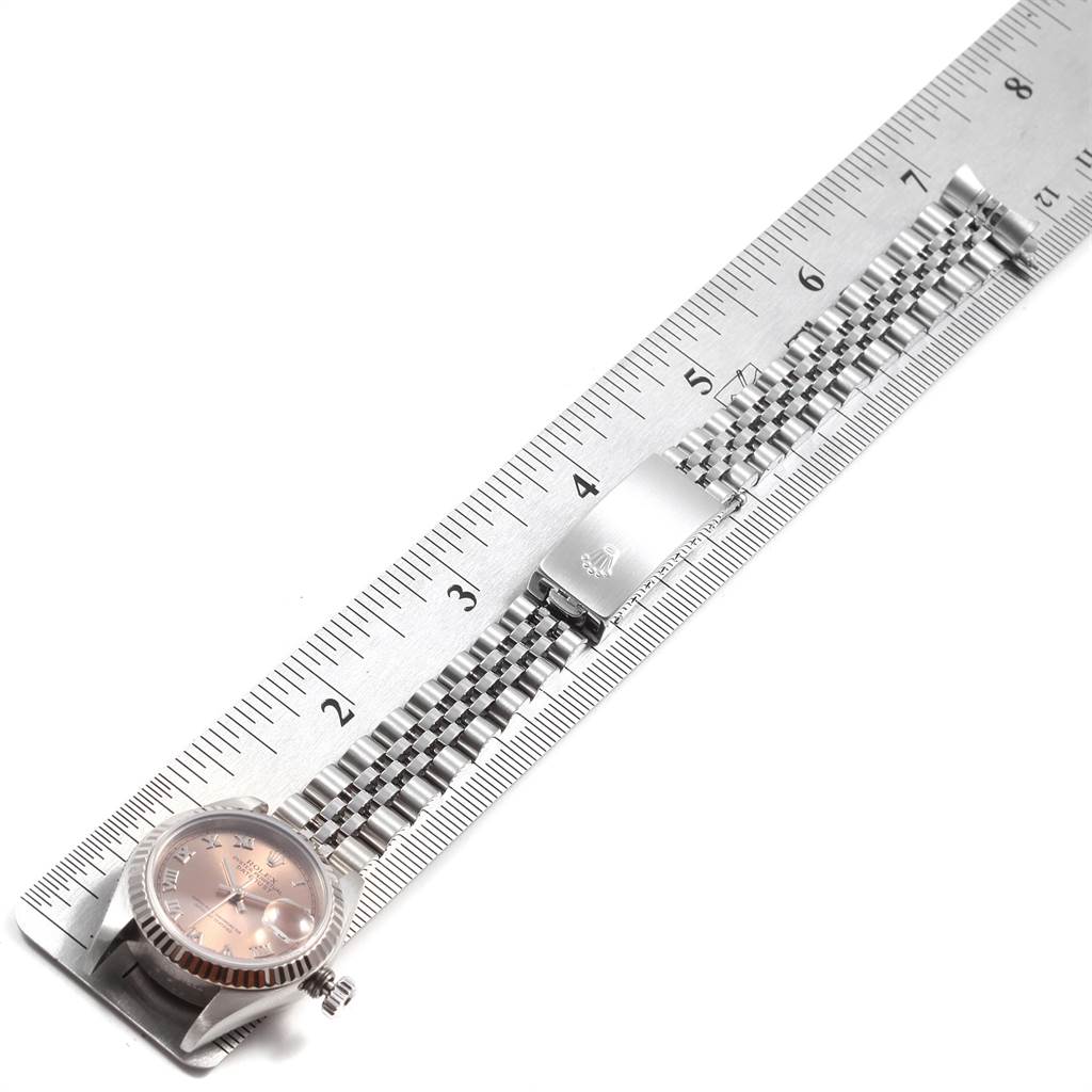 The image shows a Rolex Datejust 79174 Women
s Stainless Steel Pink Dial 79174 Women
s Stainless Steel Pink Dial watch laid flat next to a ruler, displaying the watch face and the bracelet.