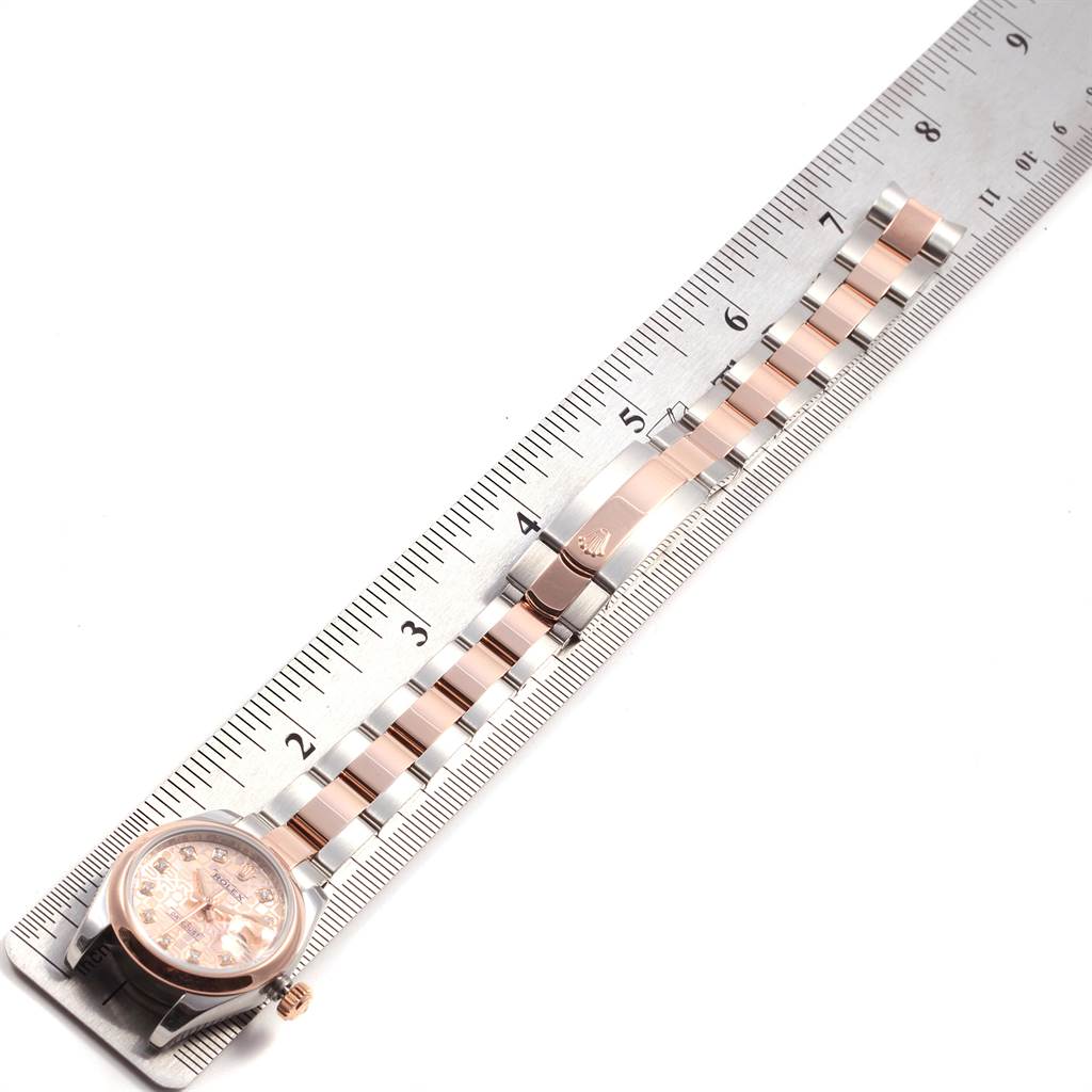 The image shows a top-down view of a Rolex Datejust 179161 Women's Steel and Gold (two tone) Pink Dial 179161 Women's Steel and Gold (two tone) Pink Dial watch and its bracelet placed alongside a ruler for measurement.