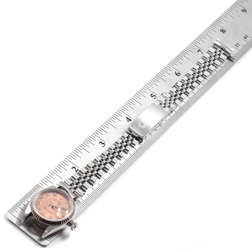 The image shows a Rolex Datejust 69174 Women's Stainless Steel Pink Dial 69174 Women's Stainless Steel Pink Dial watch laid flat on a ruler, displaying its face, bezel, crown, and bracelet.