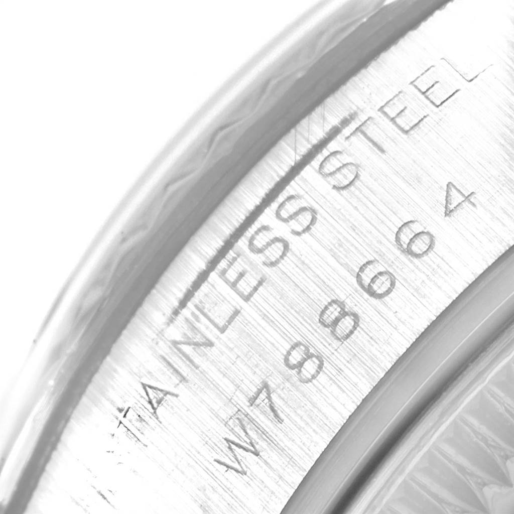 The image shows a close-up of the edge of a stainless steel Rolex Datejust 69174 Women
s Stainless Steel Blue Dial 69174 Women
s Stainless Steel Blue Dial watch case with engraved text.