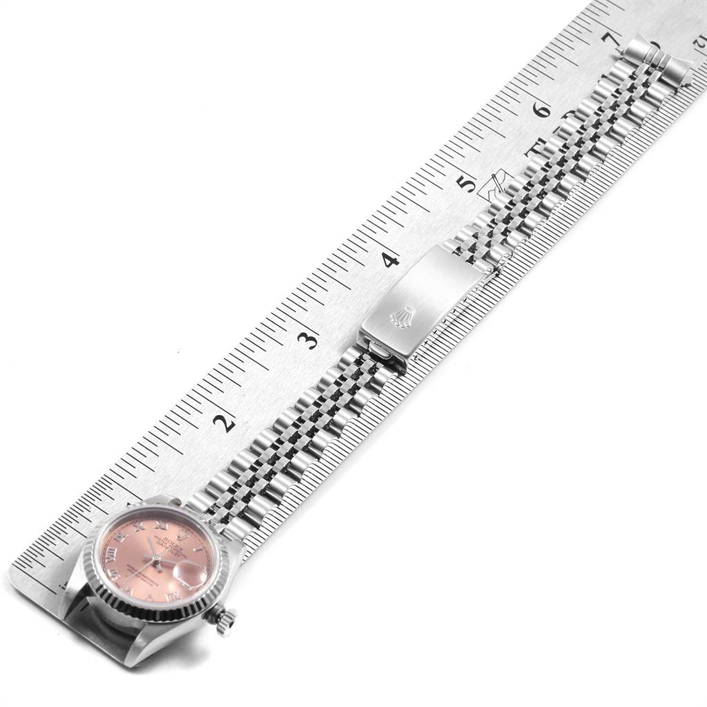 The image shows a Rolex Datejust 79174 Women
s Stainless Steel Pink Dial 79174 Women
s Stainless Steel Pink Dial watch laid flat against a ruler, displaying the dial, bracelet, and clasp.