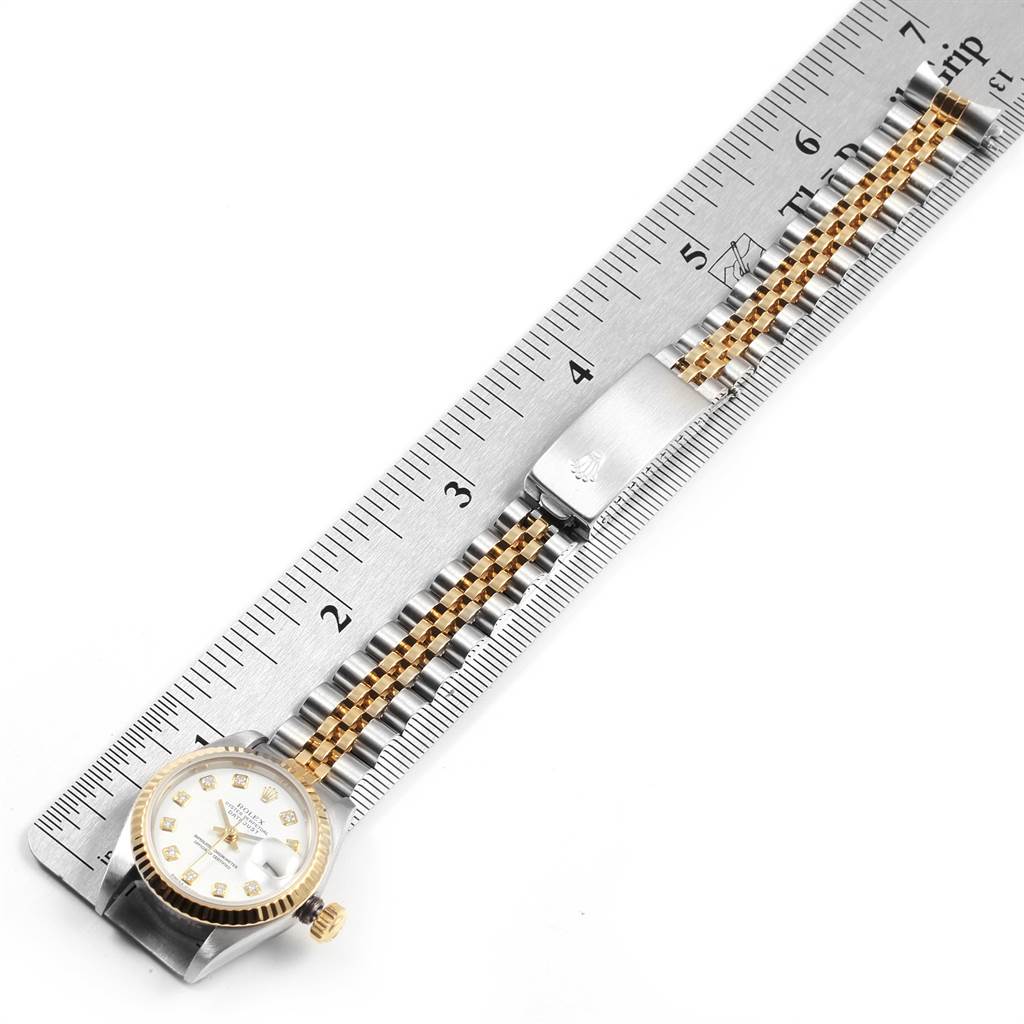 The image shows a Rolex Datejust 79173 Women's Steel and Gold (two tone) White Dial 79173 Women's Steel and Gold (two tone) White Dial watch lying flat, with the dial, crown, and bracelet visible, against a measuring ruler.