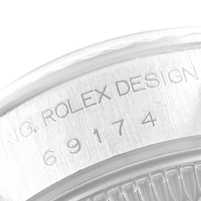 This close-up image of a Rolex Datejust 69174 Women
s Stainless Steel Blue Dial 69174 Women
s Stainless Steel Blue Dial watch shows the engraved serial number and part of the bezel from the side.